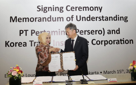 이인호 한국무역보험공사 사장(오른쪽)과 니케 위드야와티 페르타미나 사장이 15일 업무협약을 체결한 뒤 악수하고 있다.  <무역보험공사 제공>